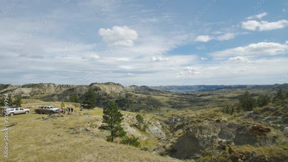 Distant group of bikers take break looking over Missouri River breaks canyon Distant group of bikers take break looking over Missouri River breaks canyon