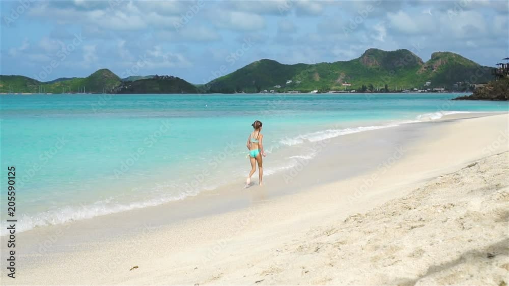 Little happy girl splashing. Kid running to the turquoise water ready to swim Little happy girl splashing. Kid running to the turquoise water ready to swim