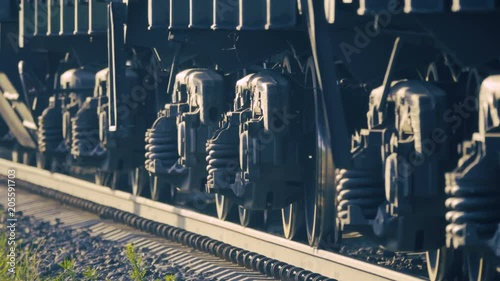 Low angle shot of the wheels of a moving freight train photo