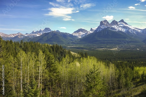 Three Sisters Mountains Scenic Landscape View and Distant Alberta Foothills in Springtime near Banff National Park, Canadian Rocky Mountains