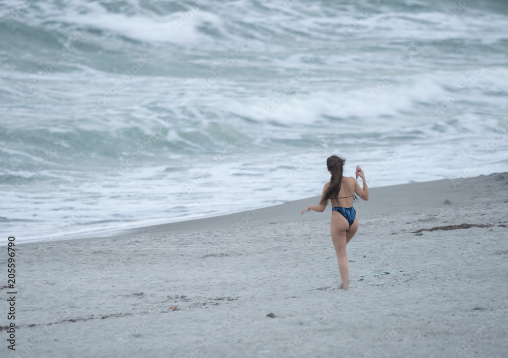 Fototapeta premium unknown woman stops to take a picture of the massive waves
