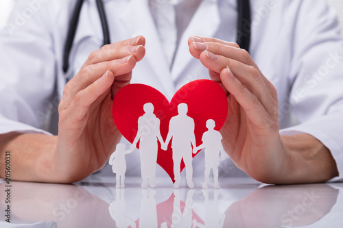 Doctor Protecting Family Cut Out With Heart Shape