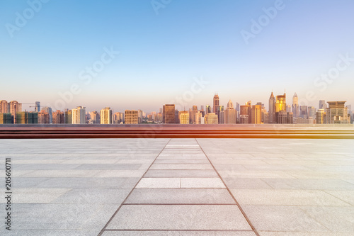 empty floor with skyline and buildings in sunrise