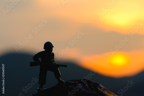 Army hold gun on mountains silhouette