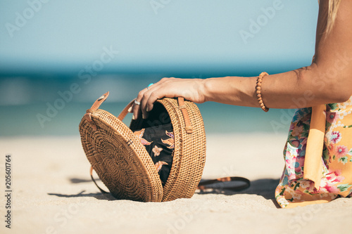 Woman with fashionable stylish rattan bag and silk scarf outside. Tropical island of Bali, Indonesia. Rattan handbag and silk scarf.