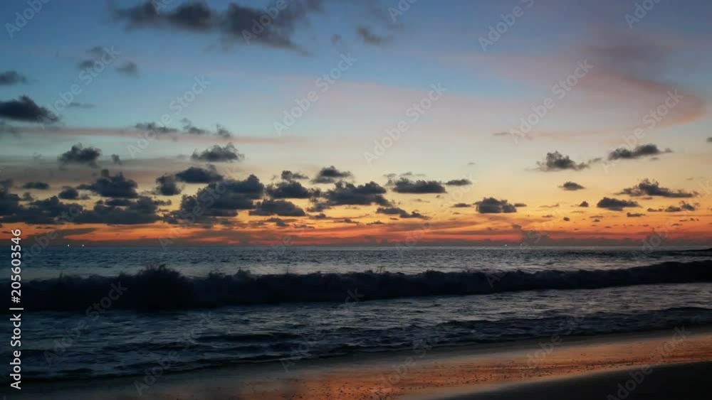 colorful golden blue twilight cloudy sky after sunset in ocean sea Surin beach at Phuket southern Thailand. Waves hit sandy beach. Reflection on sand beach. colorful golden blue twilight cloudy sky after sunset in ocean sea Surin beach at Phuket southern Thailand. Waves hit sandy beach. Reflection on sand beach.