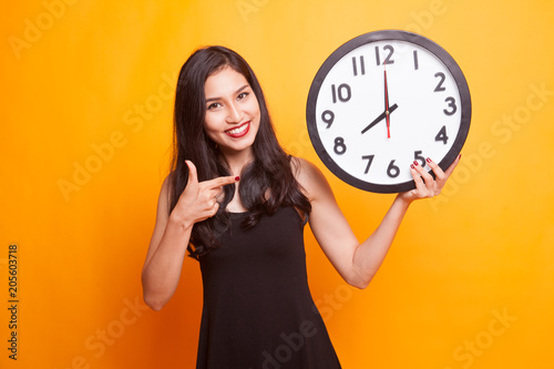Young Asian woman thumbs up with a clock.