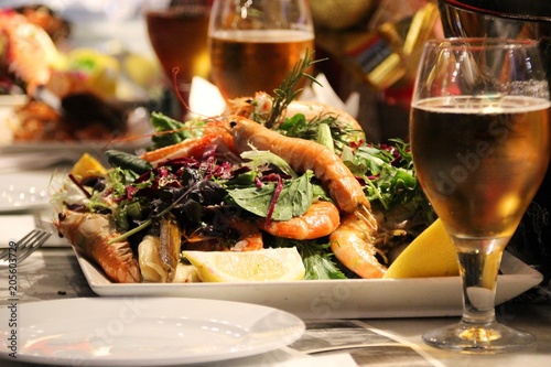 a fresh leaf salad with prawns, seafood and lemon and a cold draft beer.