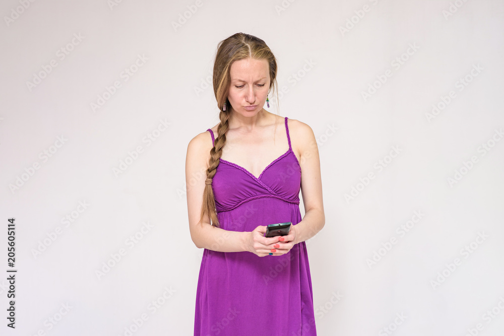Portrait of a beautiful woman using a smartphone on a white background. Portrait of a beautiful woman using a smartphone on a white background.