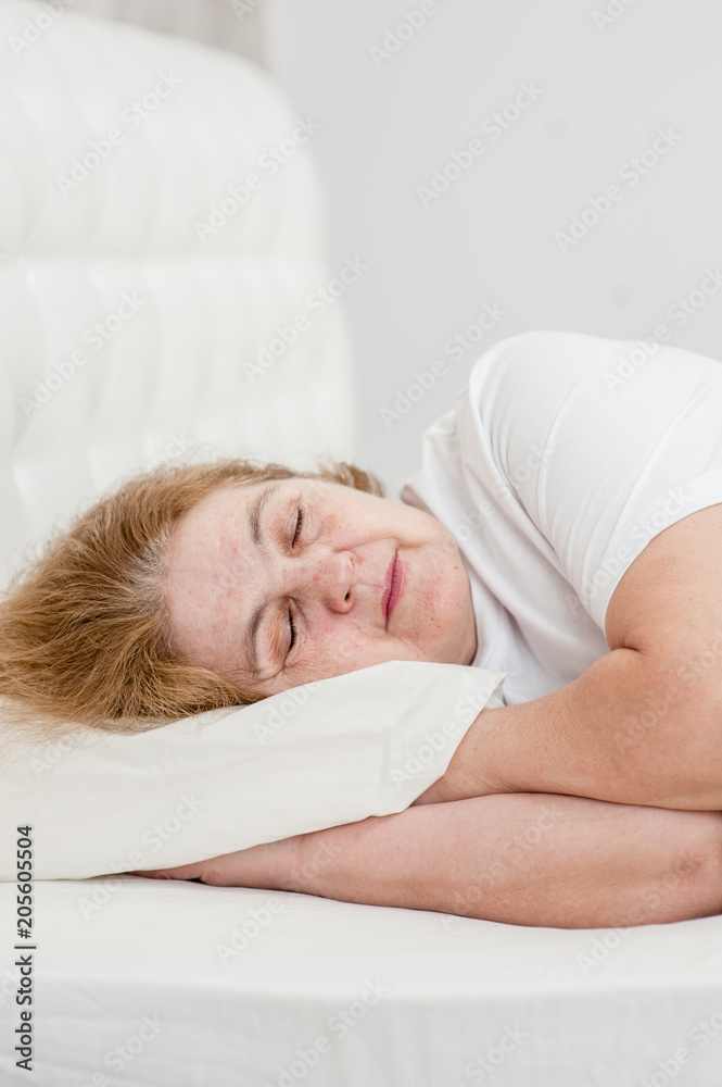 Tired senior woman sleeping on bed Tired senior woman sleeping on bed