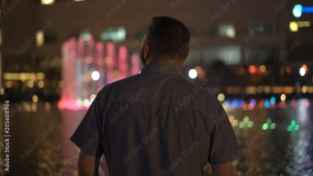 Young tourist man admire colorful fountain in the city at night
Young tourist man admire colorful fountain in the city at night