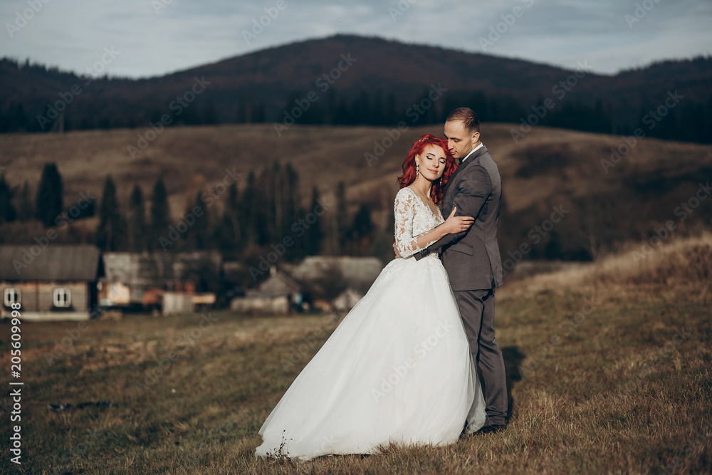 happy stylish bride and groom hugging in mountains in sunset light. gorgeous boho newlywed couple embracing, true feelings. emotional romantic moment. space for text happy stylish bride and groom hugging in mountains in sunset light. gorgeous boho newlywed couple embracing, true feelings. emotional romantic moment. space for text