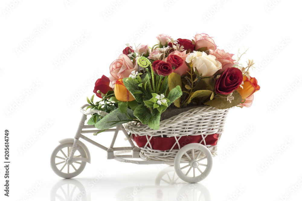 Artificial flower on toy bike vase isolated on white background