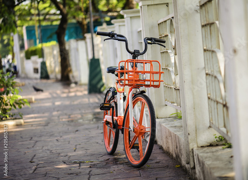 orange bicycle close to fence