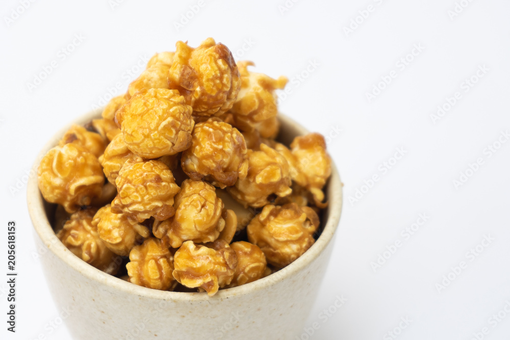 popcorn with caramel in white tiled cup isolated on white background. popcorn with caramel in white tiled cup isolated on white background.