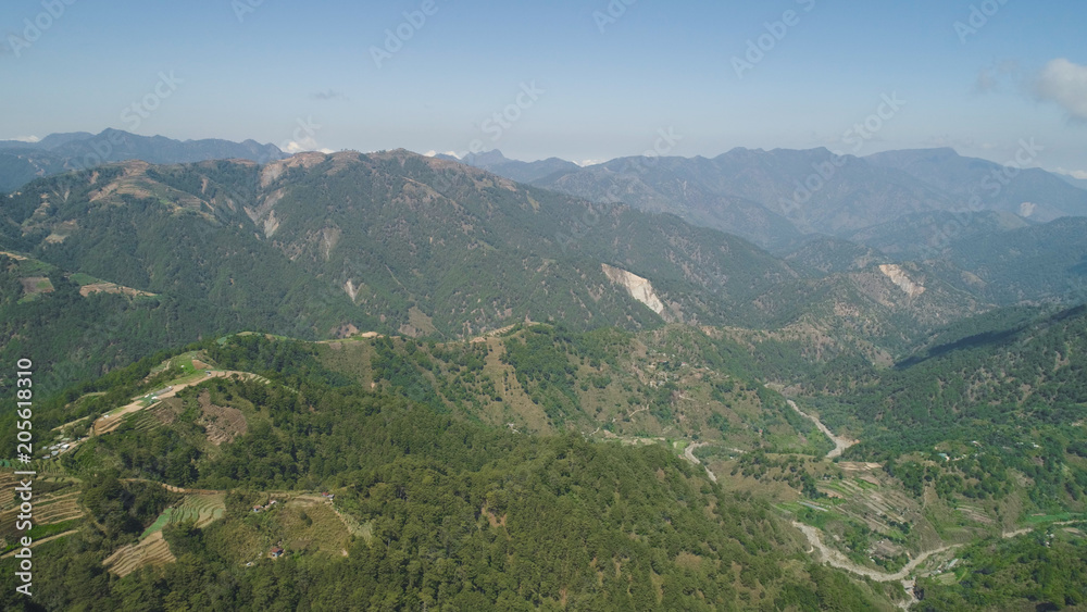 Aerial view of rice terraces and agricultural farm land on the slopes of mountains valley. Cultivation of agricultural products in mountain province. Mountains covered forest, trees. Cordillera region Aerial view of rice terraces and agricultural farm land on the slopes of mountains valley. Cultivation of agricultural products in mountain province. Mountains covered forest, trees. Cordillera region