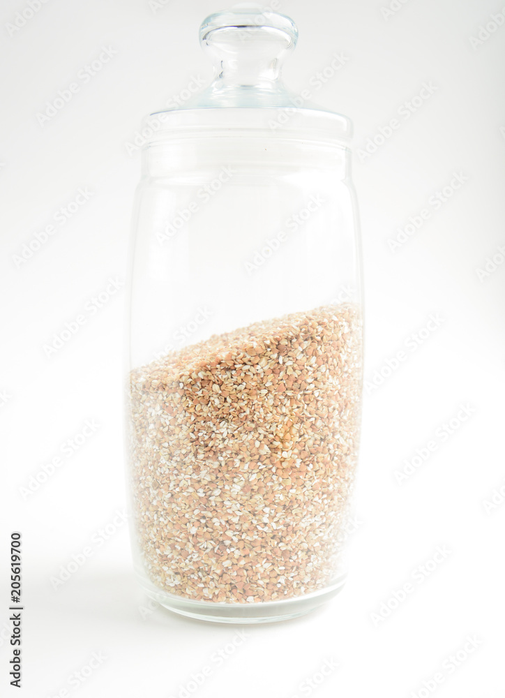 transparent glass container with buckwheat on a light background transparent glass container with buckwheat on a light background