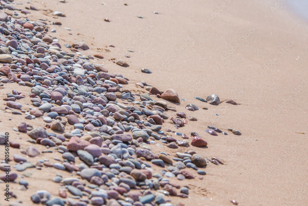 Beautiful smooth sea stones in the sands of the beach. Closeup photo of stone textures and shapes. Beautiful smooth sea stones in the sands of the beach. Closeup photo of stone textures and shapes.