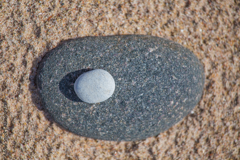Beautiful smooth sea stones in the sands of the beach. Closeup photo of stone textures and shapes. Beautiful smooth sea stones in the sands of the beach. Closeup photo of stone textures and shapes.