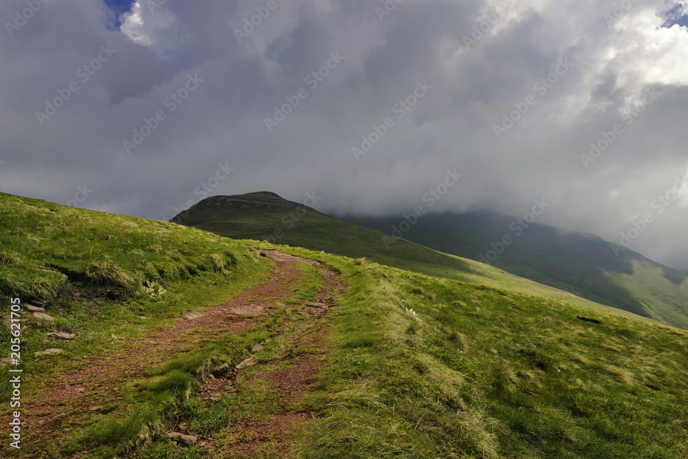 Trekking on mountain peaks. Lonely road in mountain landscape.