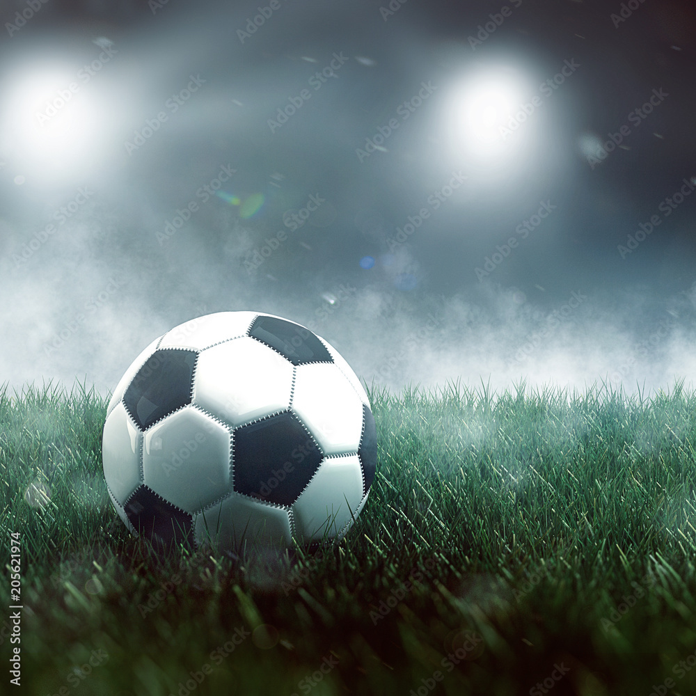 Soccer ball on grass with mist and spotlights