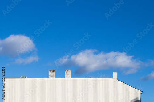 White side of a house and a blue sky with clouds