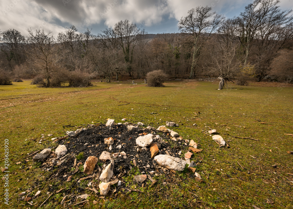 Abandoned fireplace on a meadow in Croatia on a partly cloudy day in spring