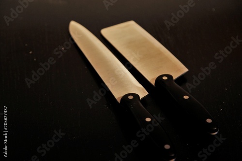A set of professional kitchen knives on a black table..