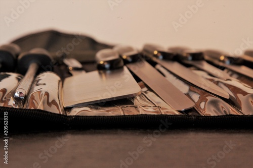 A set of professional kitchen knives on a black table..