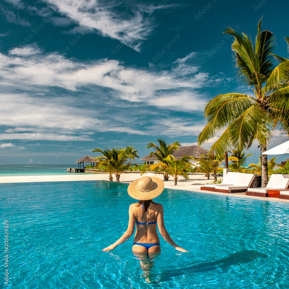 Woman with hat at beach pool in Maldives
