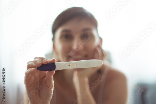 Young woman with pregnancy test in hands Positive result