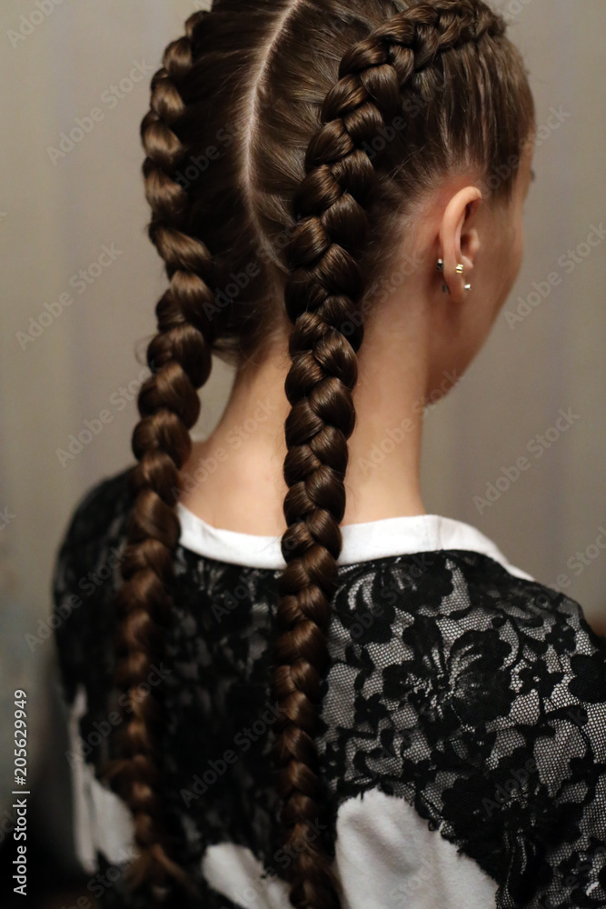 two braids, a haircut close-up of her own hair, details of the hairstyle,  hairdressing art on her head girl Stock Photo | Adobe Stock