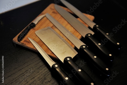 A set of professional kitchen knives on a black table..
