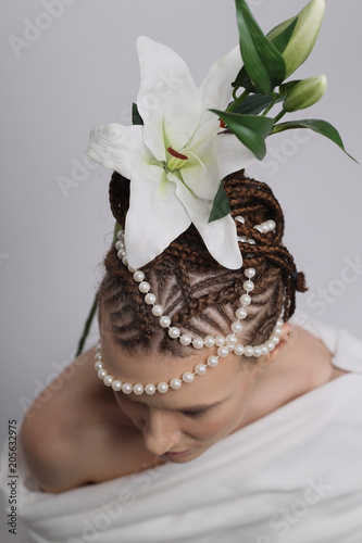 photo shoot of a girl on a white background with an exotic hairdo in an African style, a girl of European appearance