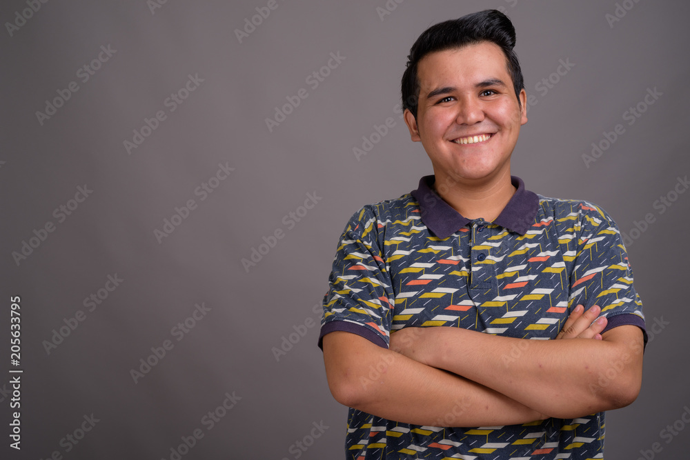 Young multi-ethnic man against gray background Young multi-ethnic man against gray background