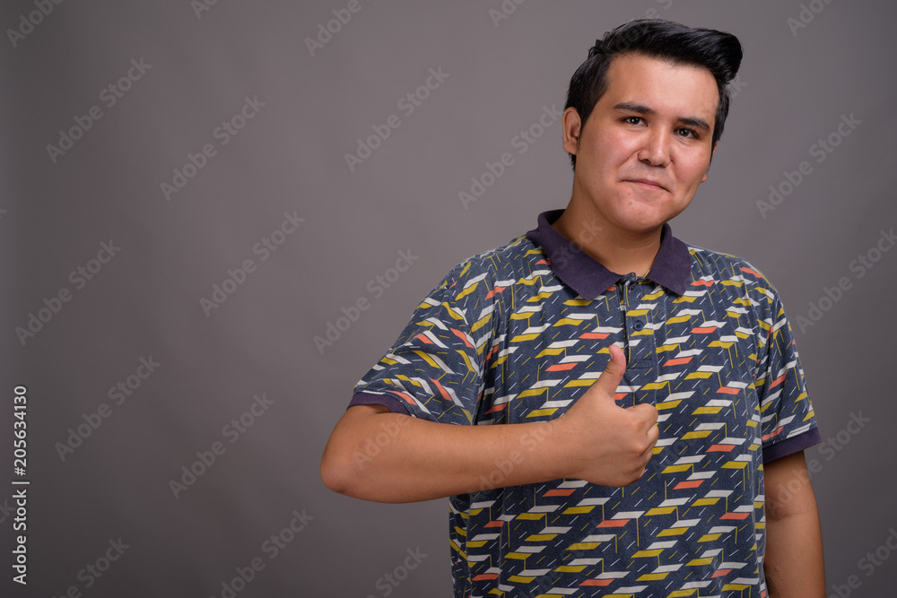 Young multi-ethnic man against gray background Young multi-ethnic man against gray background