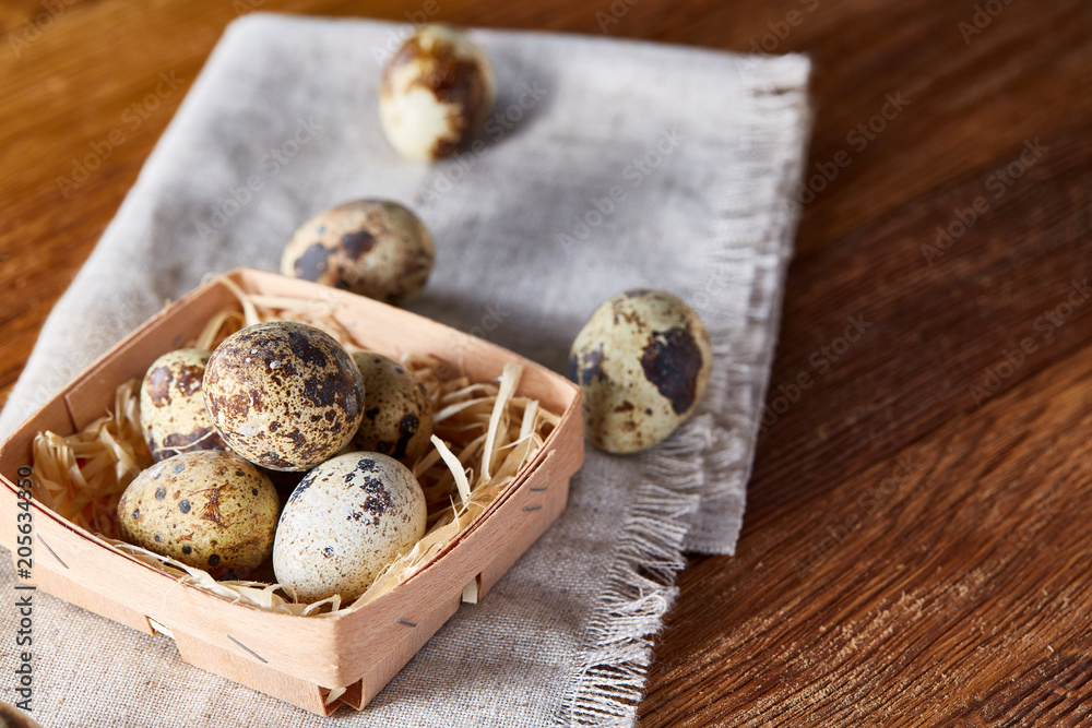 Quail eggs in the container over rustic wooden table, close-up, high angle view, selective focus. Quail eggs in the container over rustic wooden table, close-up, high angle view, selective focus.