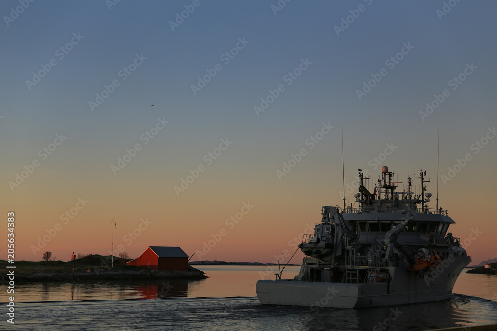 Ship in sunset passing Bronnoysund in Northern Norway