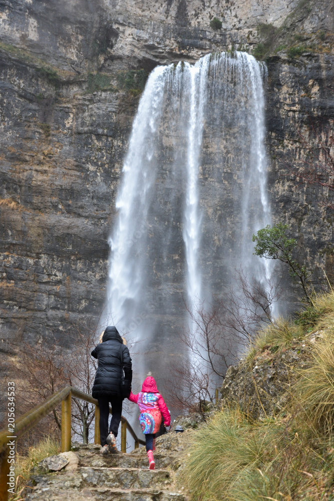 Mujer y Niña admirando la cascada en el nacimiento del Río Mundo (España)