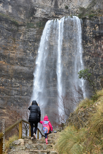 Obraz na płótnie Mujer y Niña admirando la cascada en el nacimiento del Río Mundo (España) w salonie