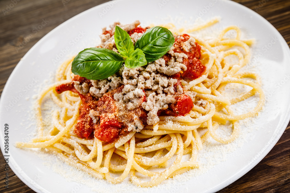 Pasta with meat and tomato sauce on wooden table Pasta with meat and tomato sauce on wooden table