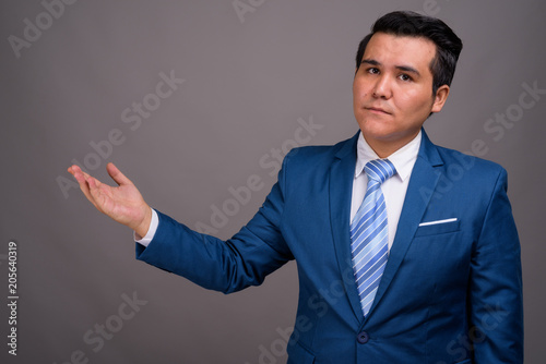 Young multi-ethnic businessman against gray background