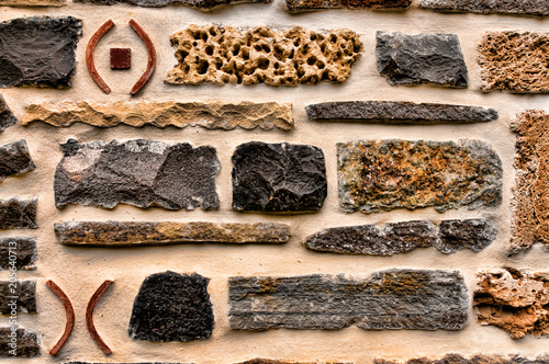 A colorful stagger of rocks and bricks cemented as a unique design for a wall. photo