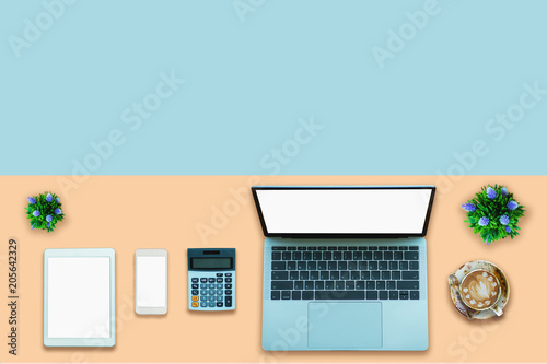 Laptop on desktop in modern office with accessories - top view on desk from above. 