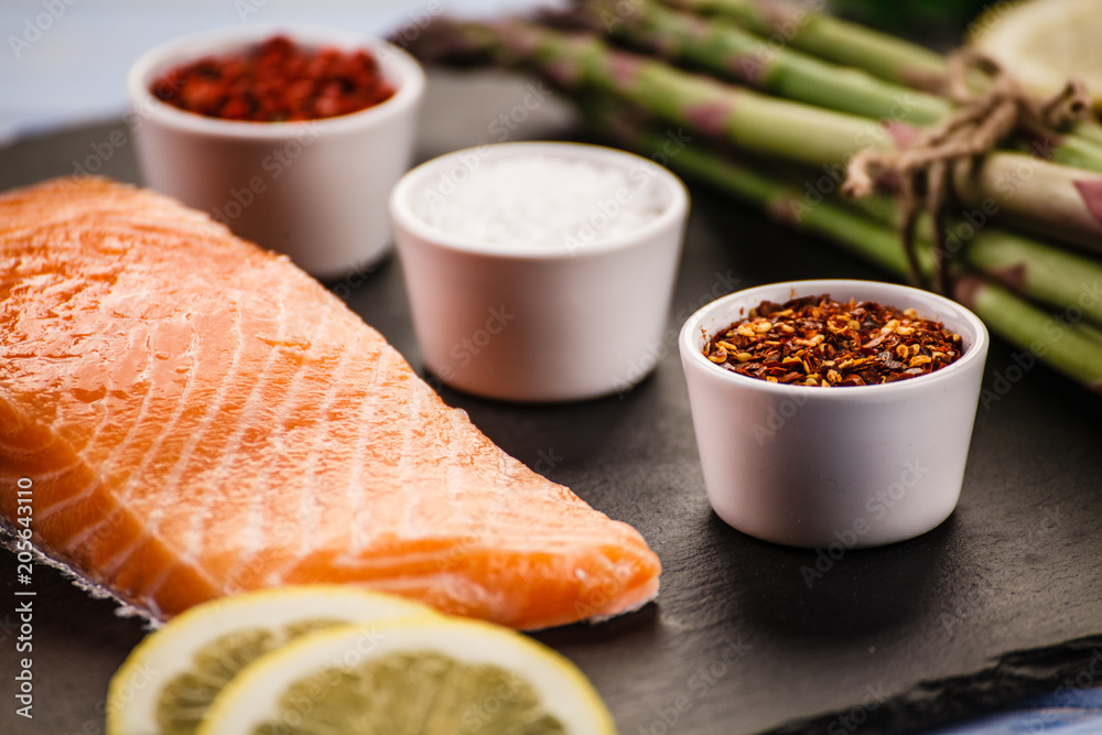 Fresh raw salmon fish served on black stone on wooden table