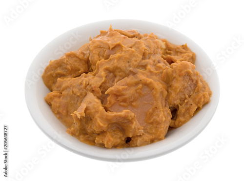 Bowl of curry flavored tuna isolated on a white background.