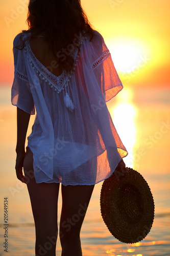 Young woman on the beach at sunset