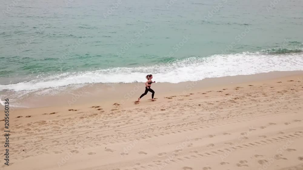 Barcelona, Spain, Mediterranean sea. The girl runs along the seashore Barcelona, Spain, Mediterranean sea. The girl runs along the seashore