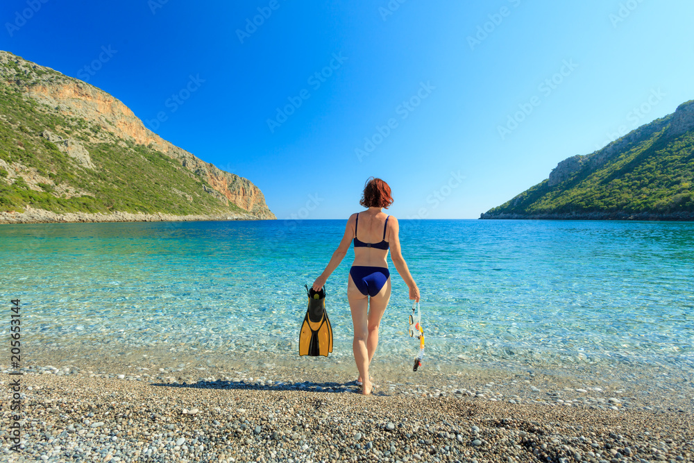 Woman with flippers snorkeling tube on beach