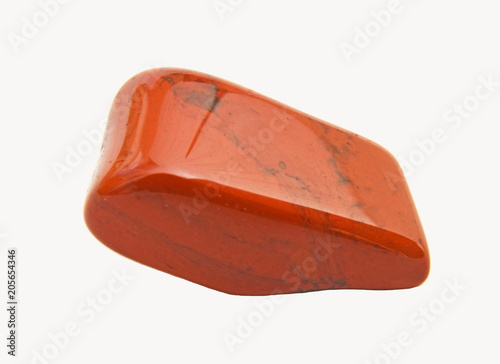 Close-up of a tumbled red jasper gemstone on white background